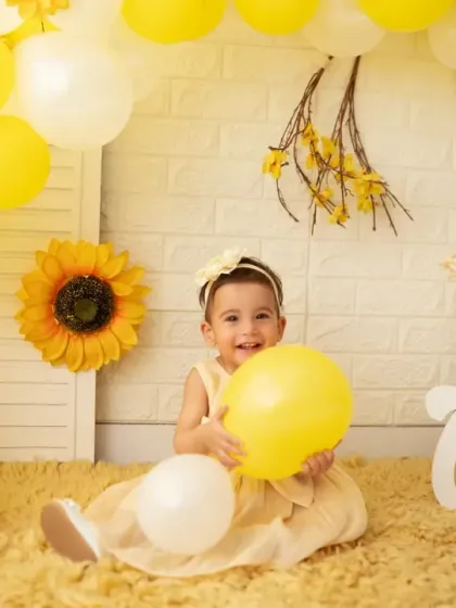 Pure happiness. The birthday girl laughs with delight during her sunshine-themed first birthday photoshoot.
