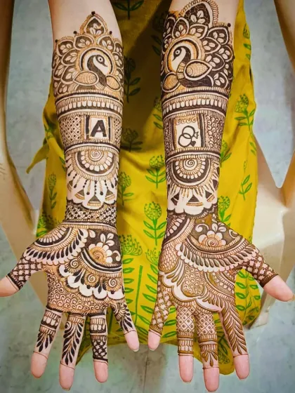 A full view of the peacock and initial mehandi, demonstrating a perfect blend of traditional animal motifs and modern personalization.
