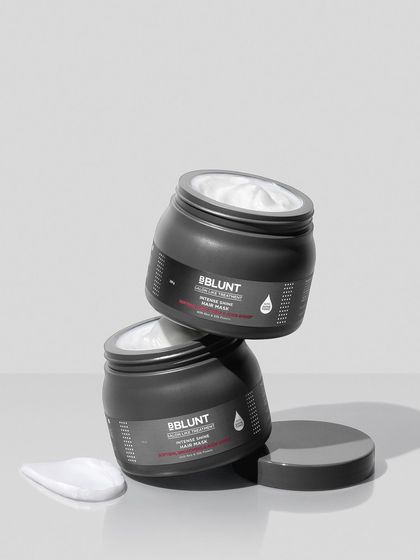 A sleek, monochromatic composition for a modern hair mask. The stacked jars create a sense of architectural balance, while the creamy swatch on the side gives a hint of the product's rich texture.