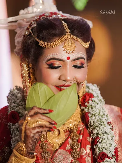 A classic portrait of a beautiful Bengali bride during the Shubho Drishti ritual, holding the betel leaves. I focus on capturing the grace and specific traditions of every culture I photograph.