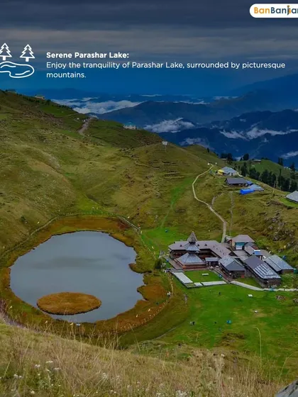 An overhead view of the serene Parashar Lake, surrounded by green hills and a clear sky. The tranquility you feel here is perfect for meditation and self-reflection.