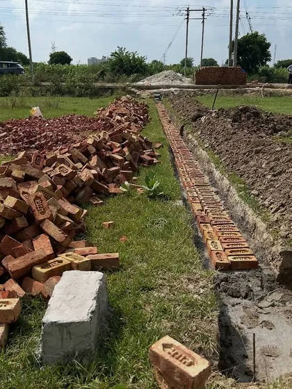 The very beginning of construction: laying the first course of bricks for the foundation trenches. This methodical process ensures the foundation is built on solid ground and to exact specifications.