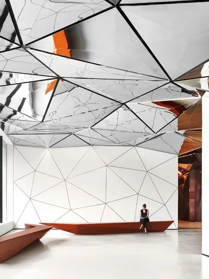 The waiting area provides a space for contemplation, where visitors can experience the kaleidoscopic effect of the ceiling. The design encourages engagement and observation.