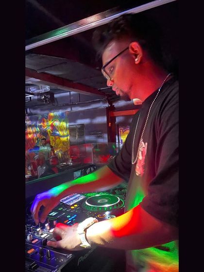 A creative shot of me at the DJ console with colorful light reflections. I bring a visual and auditory experience to every party.