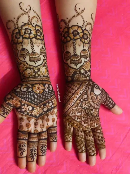 This design combines floral bouquets with hanging jhumkas and peacock motifs, blending modern and traditional elements beautifully.