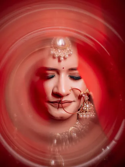 An experimental and artistic bridal portrait using a swirling red effect. This creative technique frames the bride's face beautifully, adding a dynamic and modern touch to her wedding photos.