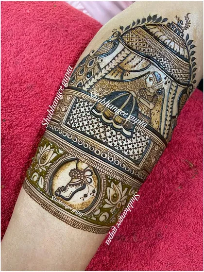 A themed arm band design for a bride who is a classical dancer. The central motif is a pair of ghungroos, or ankle bells, inside a decorative circle, showing her passion for dance.