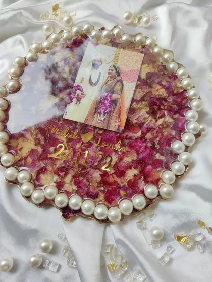 Don't let your varmala wilt away. This beautiful round frame, edged with pearls, preserves a couple's wedding photo and varmala flowers, turning them into a stunning reminder of their special day.