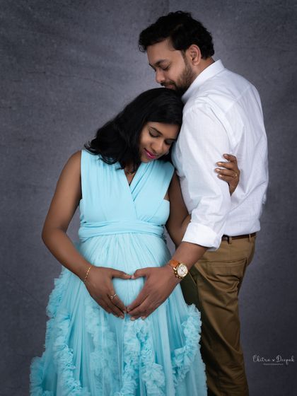 A tender moment between the couple, forming a heart shape on the baby bump. This is a classic and beloved maternity pose.
