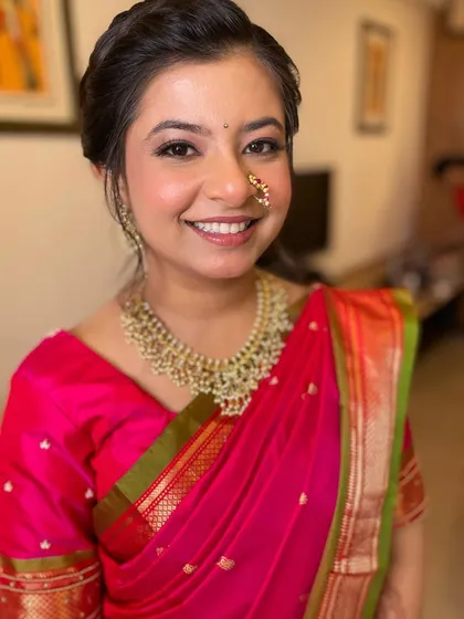 A happy portrait of the bride, looking absolutely radiant in her pink saree.