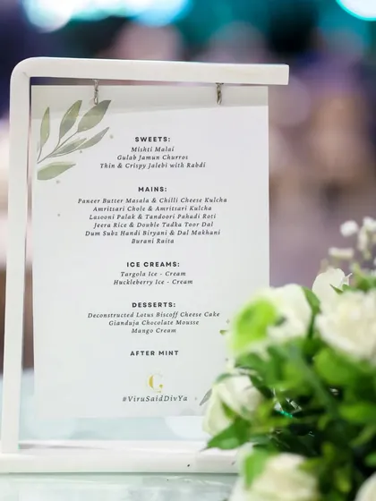 A custom menu elegantly displayed on a tabletop stand. We work with you to design every detail, including printed materials that align with your event's theme and our culinary offerings.