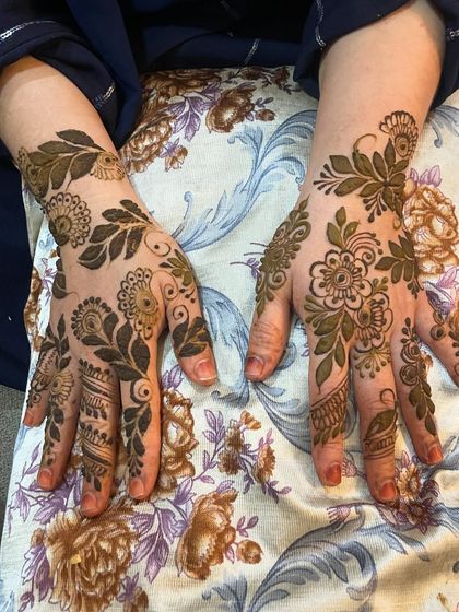 A full-hand floral design with bold leaves and delicate details, perfect for a party or festive occasion.