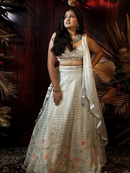A dramatic pose in the white floral lehenga, showing its versatility for photoshoots.