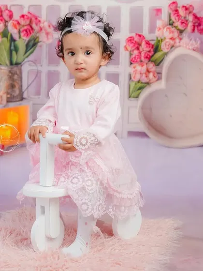 Standing confidently with her tricycle, this portrait captures a big step in her journey of milestones.