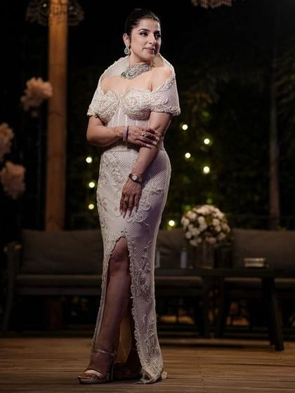 A client wearing a masterfully sculpted corset gown in ivory. This piece is an ode to contemporary couture, with its sharp tailoring celebrating both form and femininity.