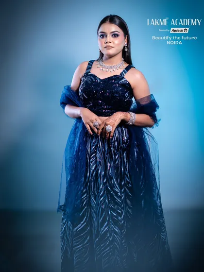 A full-length shot of a stunning cocktail party outfit and makeup. The deep blue tones and silver jewelry are perfectly complemented by a cool-toned smokey eye.