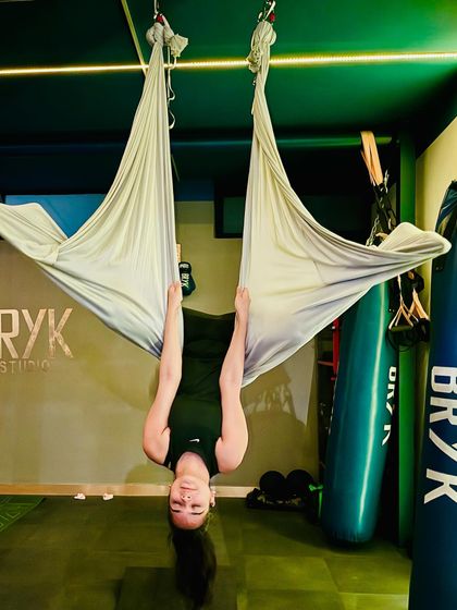 The "vampire" pose, hanging upside down, is a classic aerial move that fully decompresses the spine and builds upper body strength.