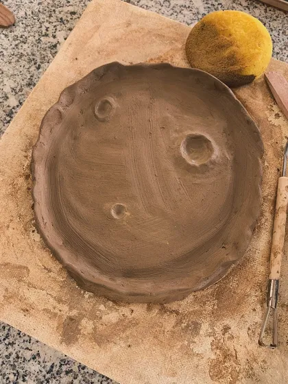 A hand-built plate with a moon-like surface, complete with craters. A simple yet imaginative piece.