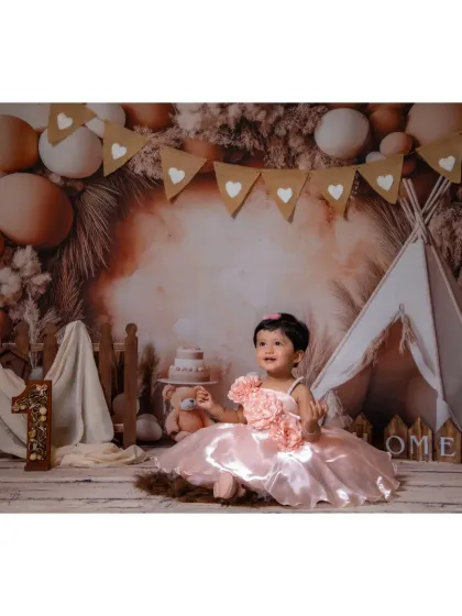 A wide shot of the boho setup, complete with a teepee and heart-shaped bunting, perfect for a first birthday.