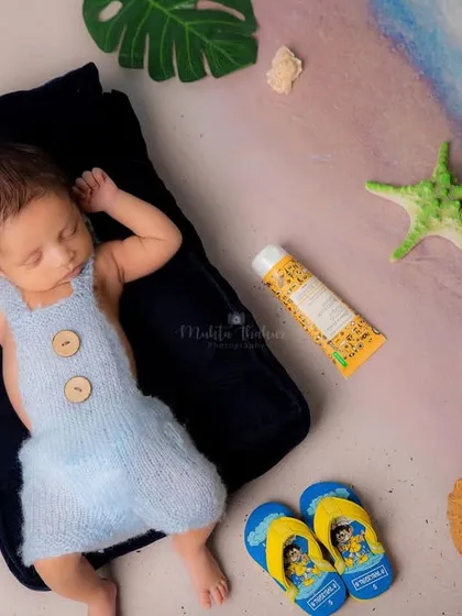 Sleeping soundly by the shore. The soft blue outfit and gentle lighting create a peaceful, seaside atmosphere for this newborn session.