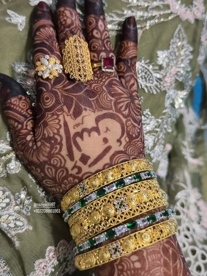 A close-up of a personalized henna design, featuring a cute caricature and initials.