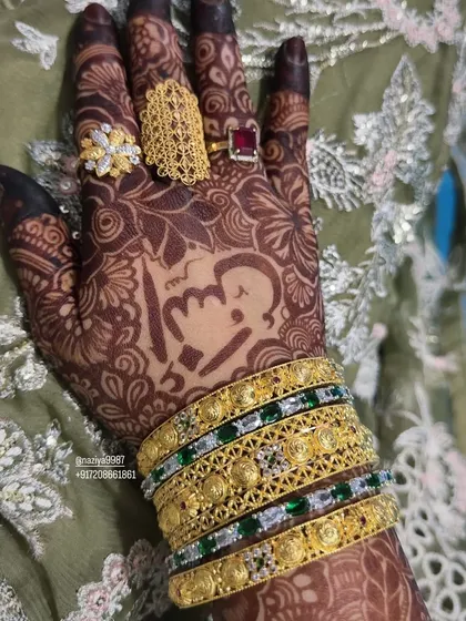 A close-up of a personalized henna design, featuring a cute caricature and initials.