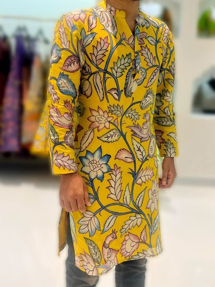 For the men, I offer custom Pen Kalamkari silk kurtas from my Vruksham Series. This vibrant yellow kurta is covered in hand-painted flora and fauna motifs, perfect for making a statement at any festive occasion.