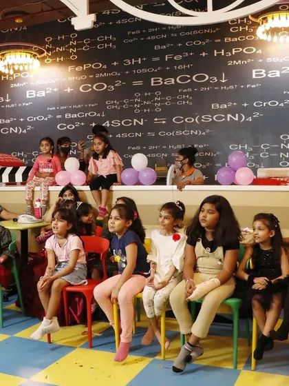 A captive audience of children eagerly watches a magic show or entertainment.