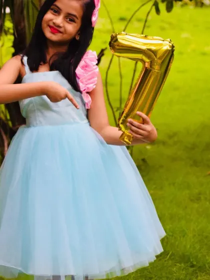 Making birthday outfits extra special is my passion. I designed this sky blue tulle frock with a pink floral shoulder detail for a little girl's 7th birthday party.