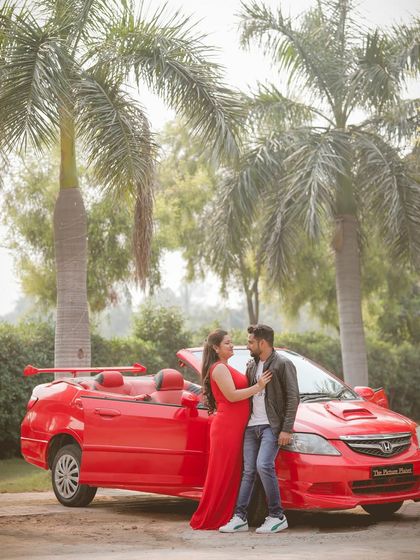 A beautiful pre-wedding shot featuring a couple and a red convertible against a backdrop of palm trees, creating a cool, retro vibe.