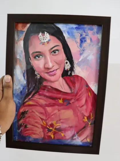 A framed oil portrait of a woman in traditional Punjabi attire. The abstract background complements the vibrant colors of her dress.
