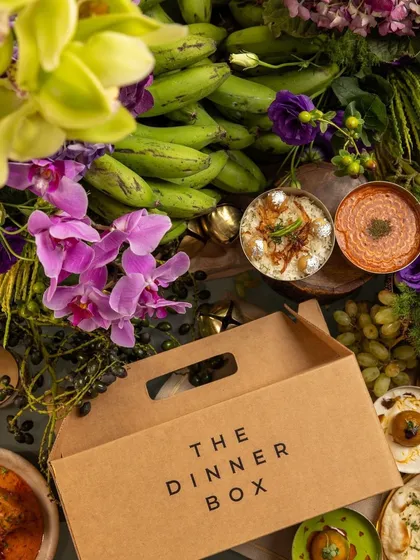 Our Dinner Box sits open amidst a lavish spread of our 'RUMI' Diwali dishes, inviting you to explore the feast inside.