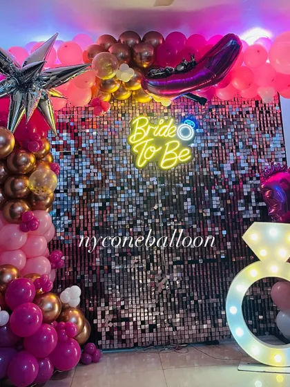 A close-up of the 'Bride to Be' party setup. The combination of the neon sign, sequin wall, and themed balloons makes for a vibrant and exciting party atmosphere.