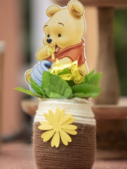 A sweet little centerpiece for the Winnie the Pooh party. I used a twine-wrapped jar and a small Pooh cutout to create these charming table decorations.