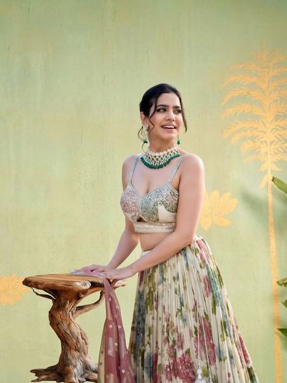 A cheerful shot in a beautiful floral lehenga, perfect for a spring or summer wedding theme. The pastel colors are soft and elegant.
