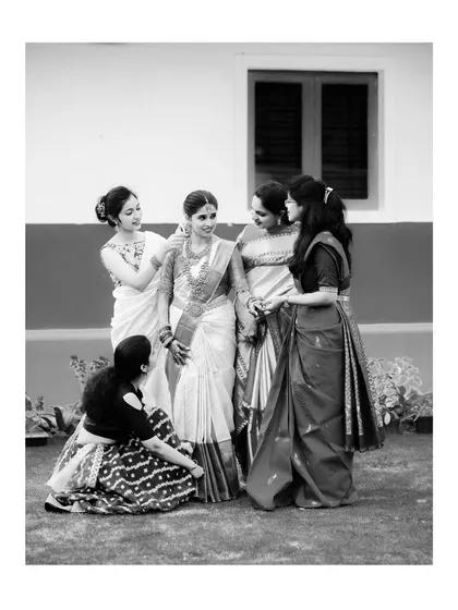 A timeless black and white photo of the bride sharing a moment with her bridesmaids, a beautiful memory of friendship on her special day.