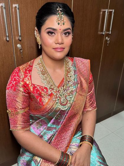 A radiant Pellikuthuru look. The makeup is kept fresh and bright, with a pop of color on the lips to match her vibrant saree.