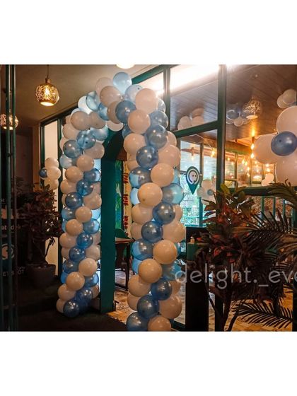 This balloon arch in shades of blue and white creates an inviting doorway for a party at a local cafe. It's a great way to signal to guests where the celebration is and set a festive tone from the moment they arrive.