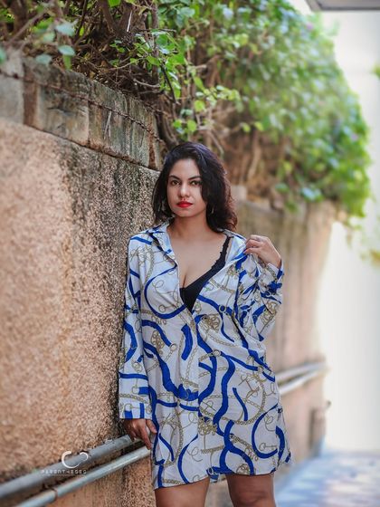 Leaning against a rustic wall, this portrait has a relaxed yet confident vibe. The natural light and trailing ivy add a touch of softness to the urban setting.