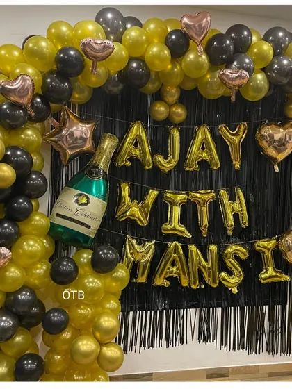 A stylish black and gold backdrop for an anniversary celebration. I can customize the foil balloons with any names or messages.