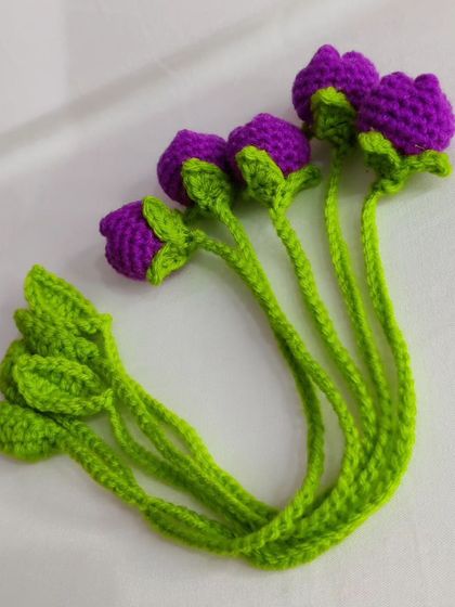 A bundle of dark purple tulip bookmarks with bright green stems.
