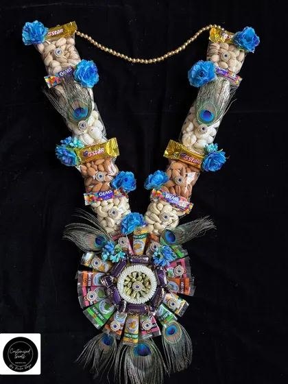 A grand garland combining the elegance of peacock feathers with the deliciousness of chocolates and dry fruits.