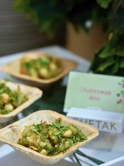 Our Chutneywale Aloo is a simple yet flavourful dish. Baby potatoes are tossed in a fresh green chutney and served in eco-friendly leaf bowls, perfect for a rustic-themed event.