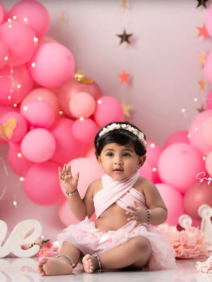 Waving hello to a new year! This little girl is all smiles during her first birthday photoshoot.