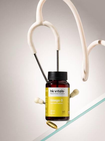 This is a conceptual shot designed to communicate health and efficacy. By combining the Omega-3 bottle with a stethoscope in a gravity-defying setup, we visually represent the product's wellness benefits in a clever, memorable way.