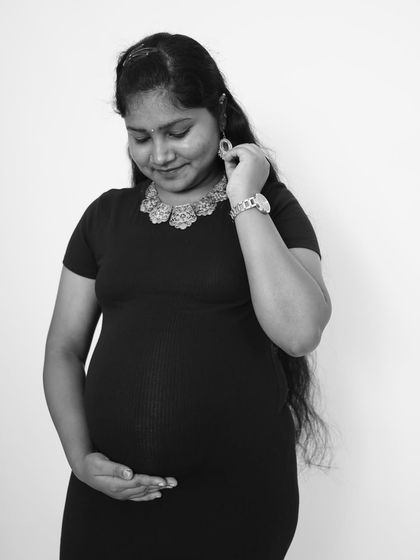 A thoughtful black and white portrait of an expecting mother. This image captures a quiet moment of reflection and anticipation.