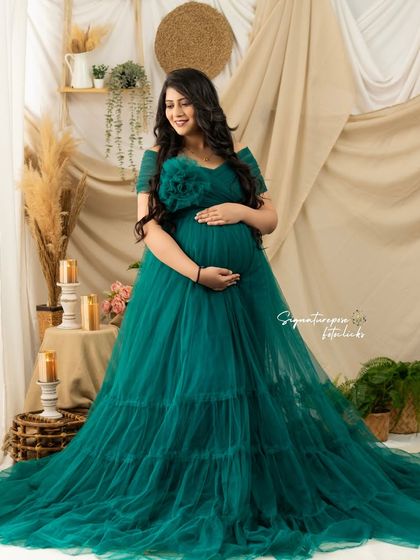 A full-view portrait showing the elegant drape of the green gown in our versatile studio setting.