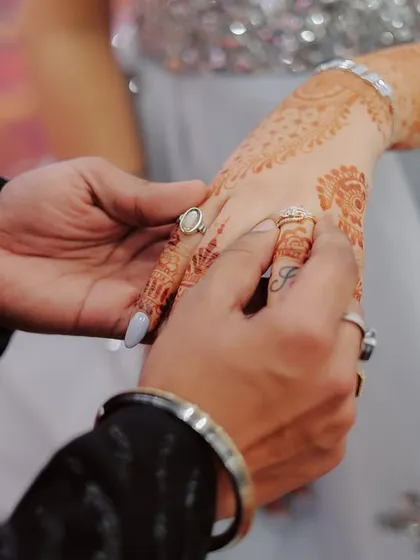 The moment it becomes official. A detailed shot of the ring being placed on the bride's finger, a key memory from any engagement ceremony.