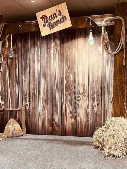 Giddy up! We created a rustic 'Ranch' themed photo booth with a wooden barn backdrop, hay bales, saddles, and ropes. This unique theme was perfect for a fun and informal get-together.