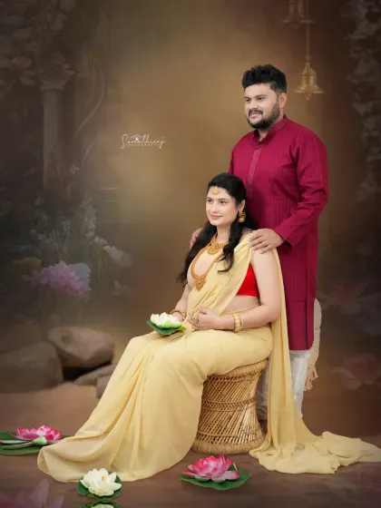 A beautiful portrait of a couple in a traditional setting, surrounded by lotus flowers. The soft lighting and elegant attire create a divine and serene atmosphere.